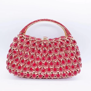 Detail of red rhinestone clutch bag with peacock feather pattern and gold metal handle