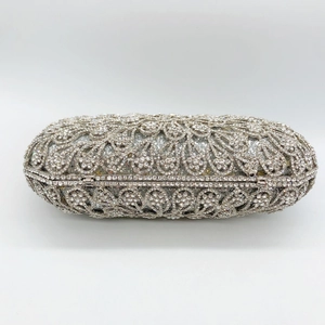 Macro detail of silver floral openwork clutch with sparkling crystal rhinestones