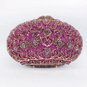 Detailed view of luxury oval clutch bag with purple rhinestones and gold metal frame