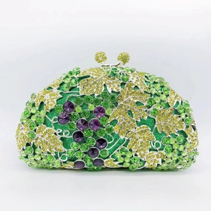 Detail view of sparkling green crystal clutch bag with 3D grape vine and leaf patterns