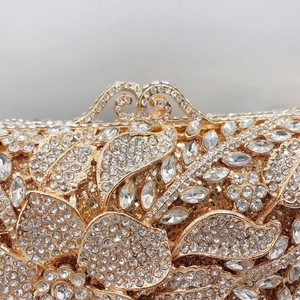 Macro di una borsa da sera dorata con strass floreali e chiusura in metallo vintage
