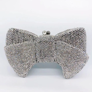 Macro detail of bow-shaped clutch bag with luxury crystal rhinestones and bead clasp