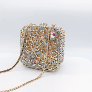 Close-up of gold evening clutch bag with crystal rhinestones and hollow floral patterns