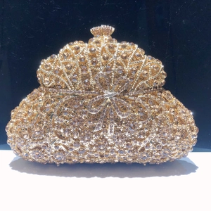 Détail de la pochette de soirée dorée champagne avec cristaux et nœud décoratif