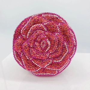 Close-up of red and pink crystal rose floral pattern on circular rhinestone clutch purse