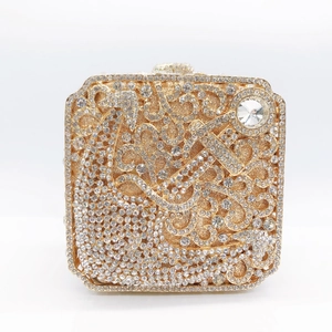 Detailed shot of golden evening clutch bag featuring intricate crystal vine scrollwork