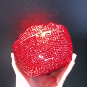 Macro shot of red lip-shaped evening clutch bag adorned with shimmering rhinestones