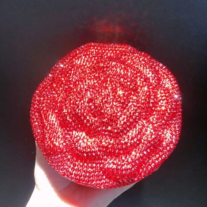 Detailed close-up of a round evening clutch bag fully embellished with sparkling red crystals