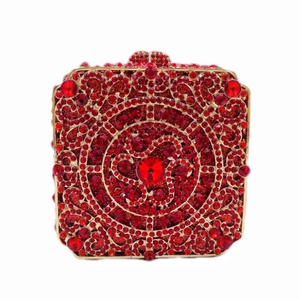 Detail of red rhinestone square clutch bag with golden vintage pattern and crystal clasp