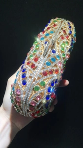 Gros plan de strass colorés sur une pochette de soirée en métal doré ajouré