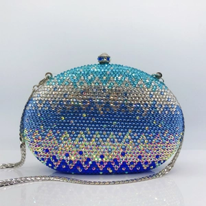 Detail of blue gradient rhinestone clutch featuring a gem-encrusted metal clasp and chain