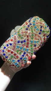Détail du fermoir cœur et strass colorés sur la pochette de soirée dorée