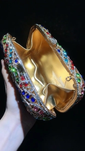 Détails d'une pochette de luxe ornée de strass multicolores et d'une monture dorée élégante