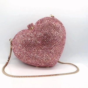 Detailed view of pink heart clutch bag with shimmering crystals and golden chain