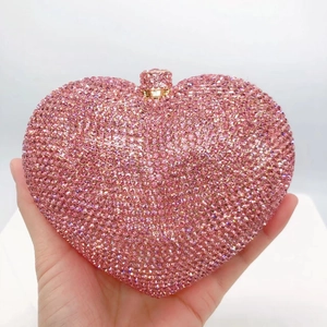 Detailed view of pink heart-shaped clutch bag encrusted with sparkling rhinestones