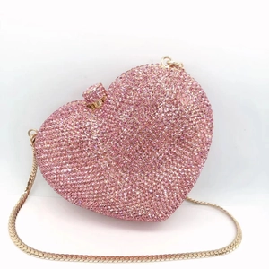 Detailed close-up of pink heart-shaped crystal clutch bag with gold chain and rhinestones