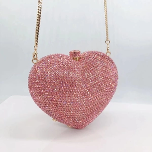 Close-up of pink heart-shaped crystal clutch featuring a gold metal chain strap