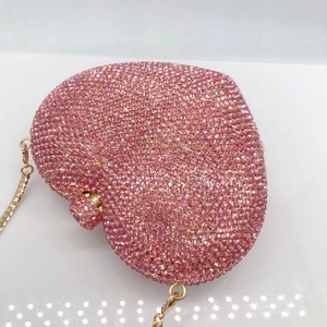 Detail of pink crystal heart clutch with sparkling rhinestones and gold chain