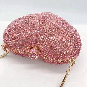 Macro detail of pink crystal rhinestones on the heart shaped evening clutch bag
