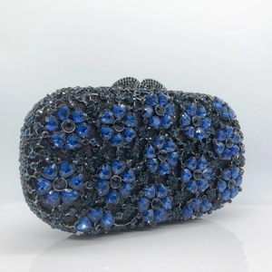 Detail of luxury evening clutch featuring intricate blue and black floral rhinestone patterns