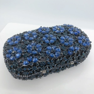 Macro detail of luxury evening clutch showing blue floral rhinestones and silver metal frame