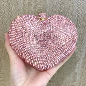 Detailed view of high-density pink rhinestones on a heart-shaped evening clutch bag