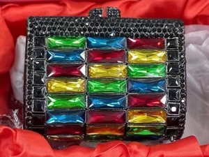 Detailed close-up of luxury rectangular evening clutch with multicolored gemstones in a box