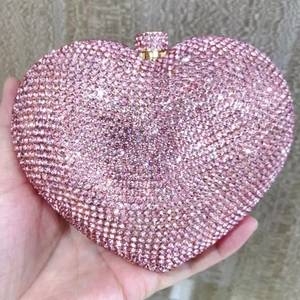 Close-up of pink heart-shaped evening clutch bag with sparkling rhinestone surface