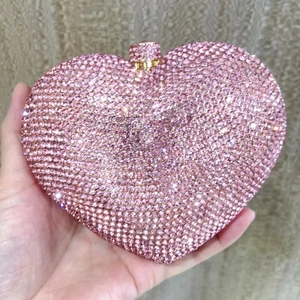 Detailed macro of a heart-shaped evening clutch bag with sparkling pink rhinestones
