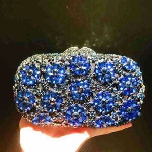 Detailed close-up of blue crystal flower pattern on an elegant evening clutch bag