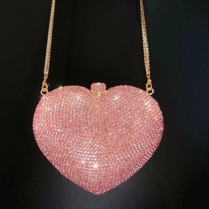 Detail of pink crystal heart clutch bag with dense rhinestones and gold chain strap