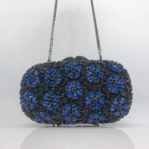 Detail of blue crystal flower pattern and silver chain on the luxury evening clutch bag