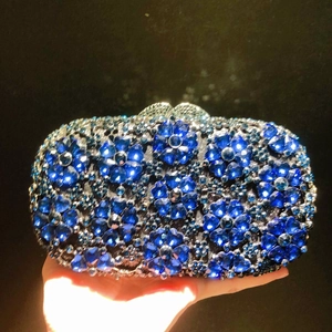 Handheld view of blue crystal flower evening clutch with sparkling rhinestones and silver clasp