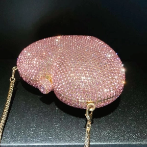 Macro detail of brain-shaped evening clutch bag with sparkling pink rhinestones and gold chain