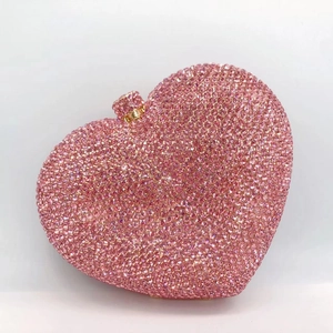 Close-up of pink heart-shaped clutch bag with luxury crystal rhinestones and metal clasp