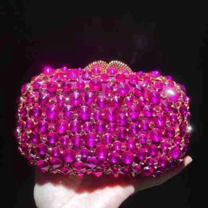 Detail of rose red rhinestone evening clutch bag with sparkling crystals and metal clasp