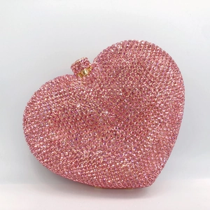 Detailed close-up of pink heart-shaped crystal evening clutch with sparkling rhinestones