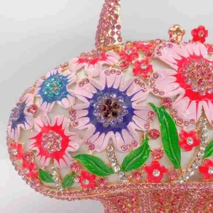 Détail macro d'une pochette de soirée florale avec émail coloré et cristaux sertis