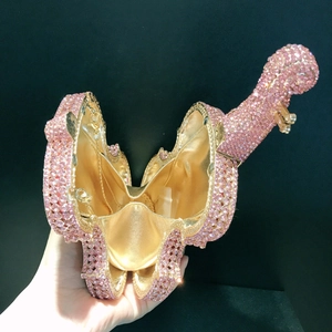 Macro shot of pink rhinestone dinosaur clutch bag with metallic gold lining detail