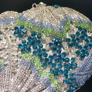 Macro shot of shimmering blue and silver rhinestone patterns on a luxury evening clutch bag