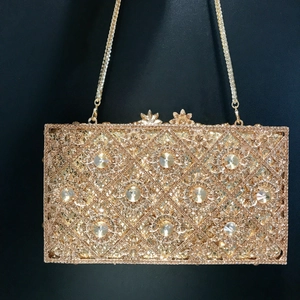 Golden sunflower rhinestone evening clutch bag with chain strap on black background