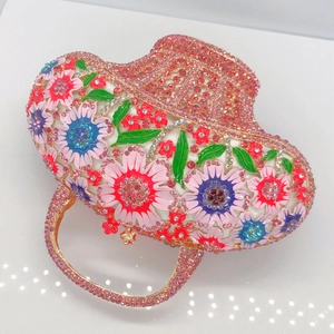 Détail de strass roses sertis main et fleurs émaillées sur cette pochette panier
