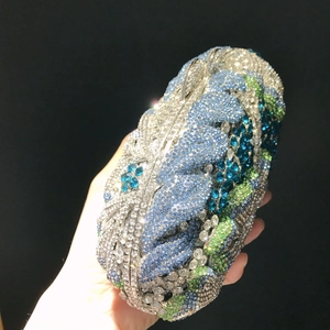 Close-up of luxury hand-held evening clutch featuring blue floral crystal rhinestones