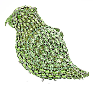 Macro shot of vibrant green crystals on a parrot-shaped metallic evening clutch bag