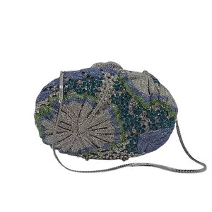 Detail of luxury evening clutch with blue floral rhinestones and silver chain strap