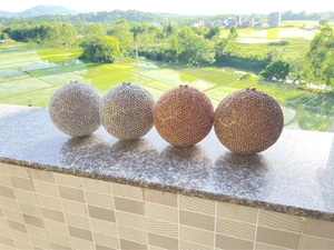 Four sphere crystal evening clutch bags in silver, rose gold and bronze on a stone ledge