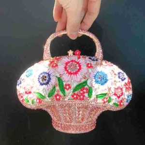 Détail de la pochette panier à fleurs avec cristaux et fleurs en émail sur fond noir