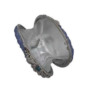Detail of blue rhinestone evening clutch interior with spare crystals and silver lining
