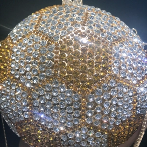 Macro detail of luxury spherical evening bag with dense gold and silver rhinestones