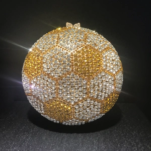 Macro view of crystal football evening bag featuring an ornate butterfly clasp closure